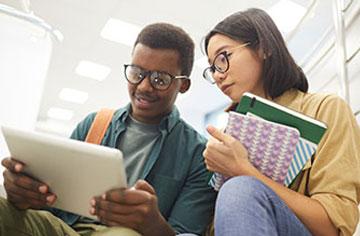 two teens looking at a tablet