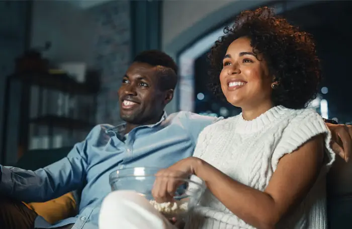 A couple snuggling and watching a program