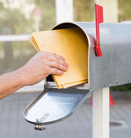 hand pulling mail out of a mailbox