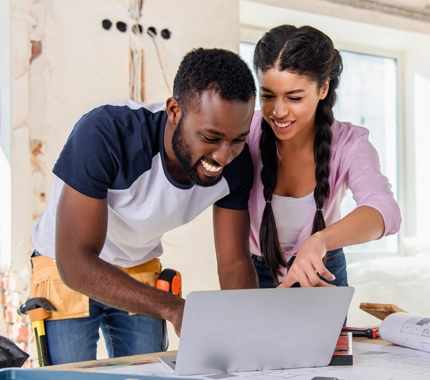 man and woman watching their laptop
