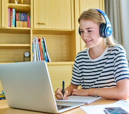 young teenager listening to course on her laptop