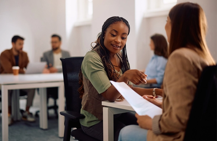 two women working and talking together